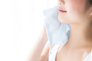 タオルで汗を拭く女性